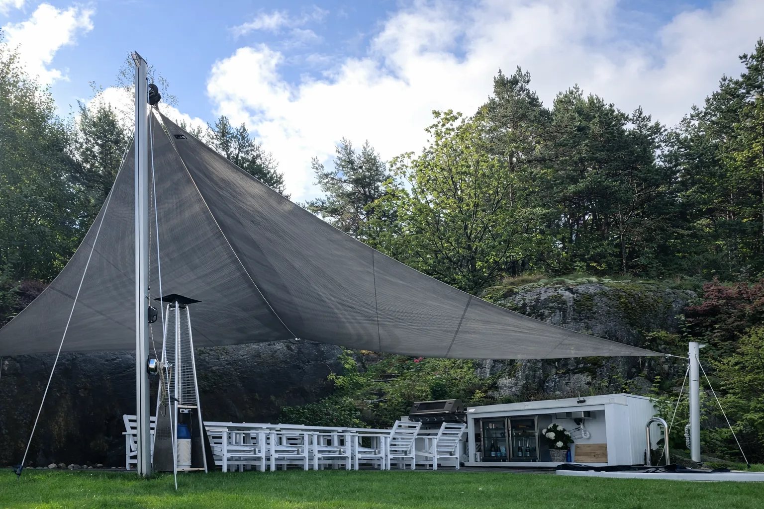 Stort mörkt solsegel i trädgård